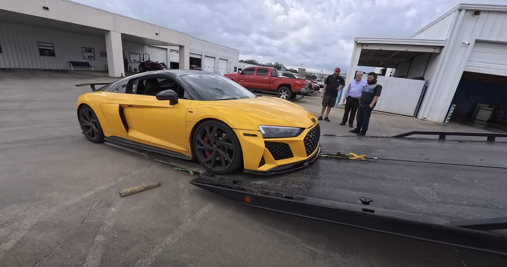 Flatbed Towing Service for Luxury and High-Performance Vehicles Luxury yellow sports car being loaded onto professional flatbed tow truck